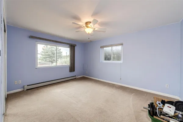 an empty room with windows and fan