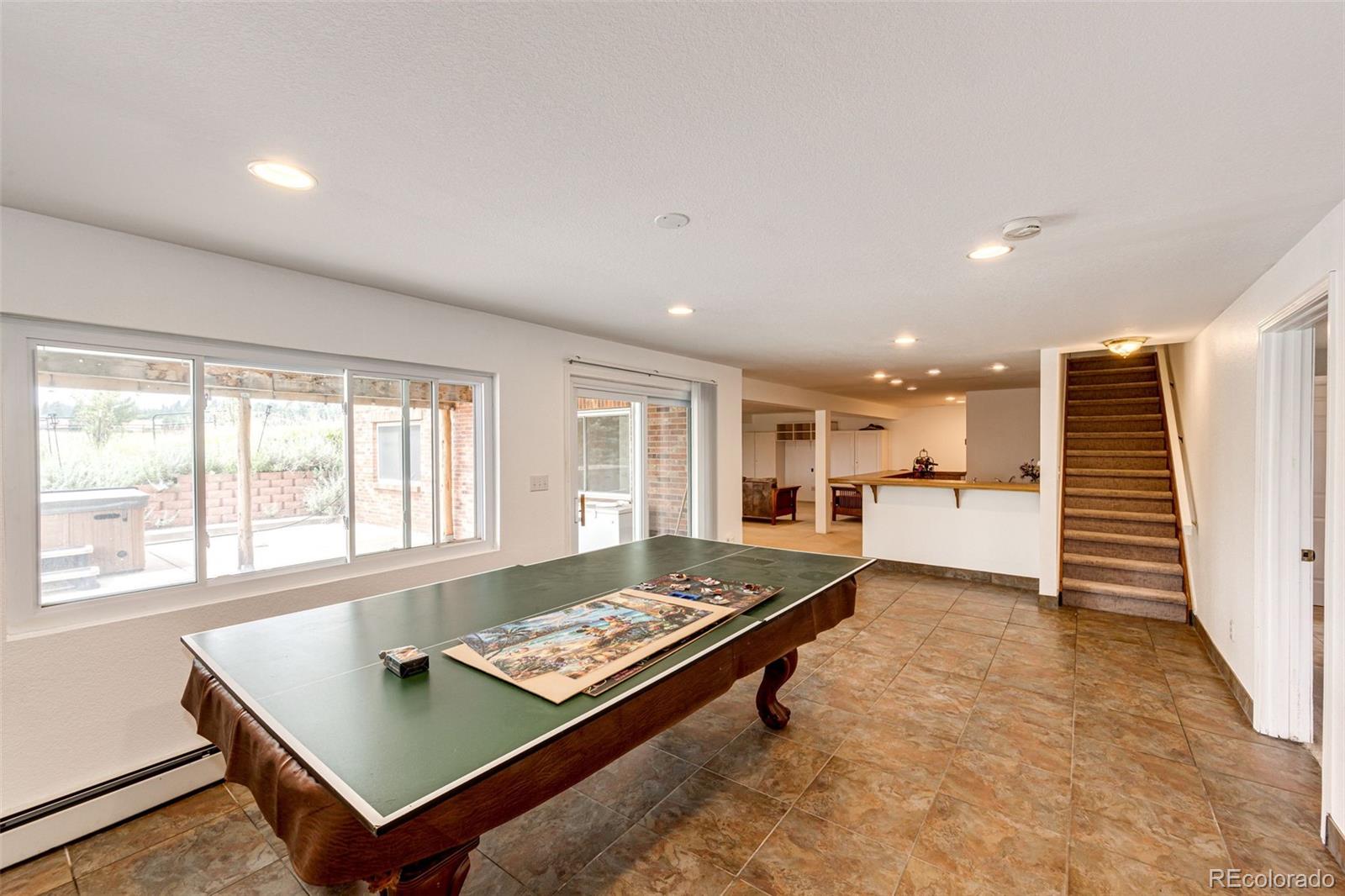 2218 Deerpath Road Franktown, CO 80116 - Photo 30 of 46 a living room with a table and a wooden floor