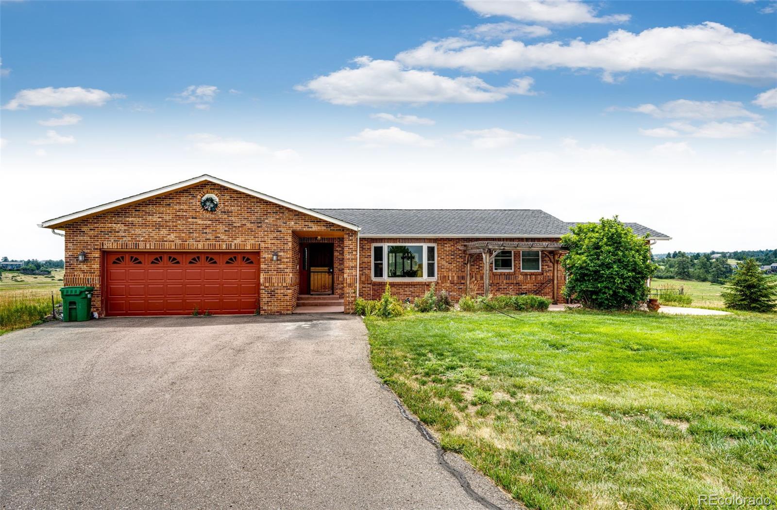 2218 Deerpath Road Franktown, CO 80116 - Photo 3 of 46 a front view of a house with garden