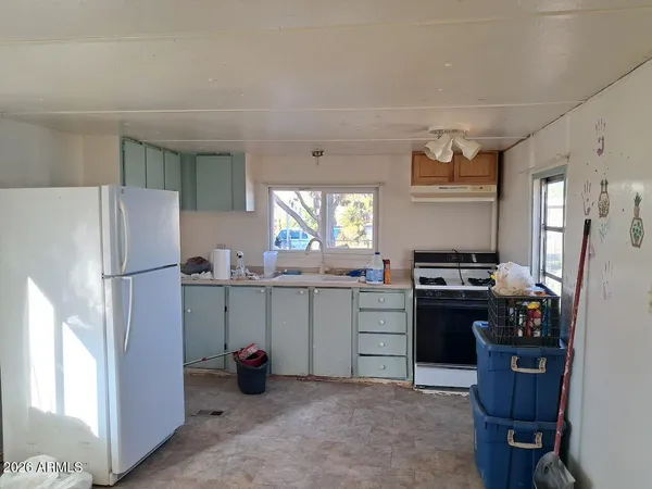 a kitchen with refrigerator a stove a sink dishwasher and wooden cabinets