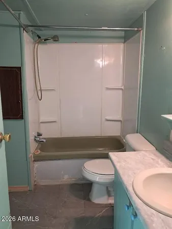 a bathroom with a granite countertop bathtub shower sink vanity and toilet