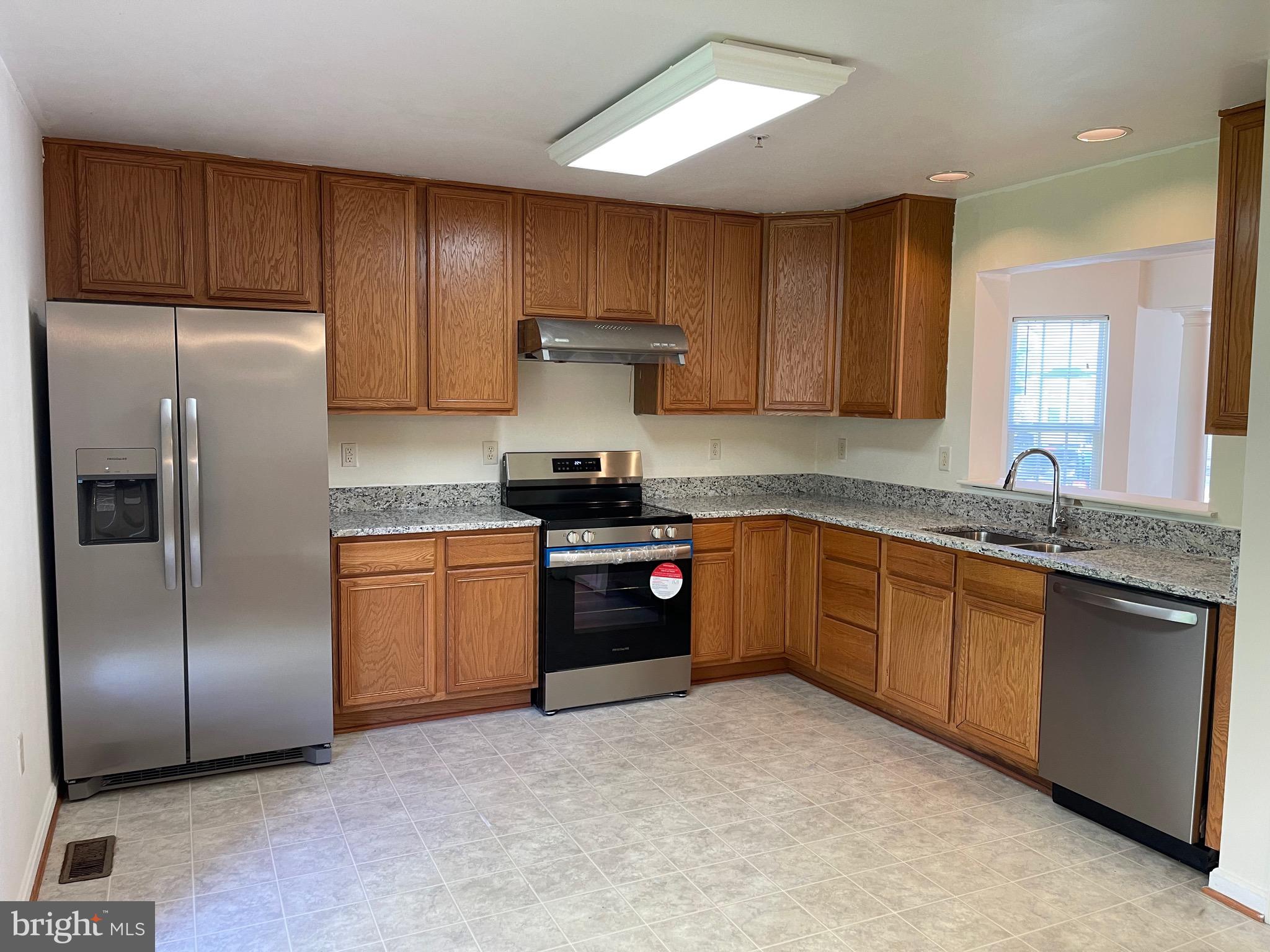 2017 Buell Drive Frederick, MD 21702 - Photo 10 of 23 a kitchen with stainless steel appliances granite countertop a refrigerator a sink dishwasher a stove with wooden cabinets and floor