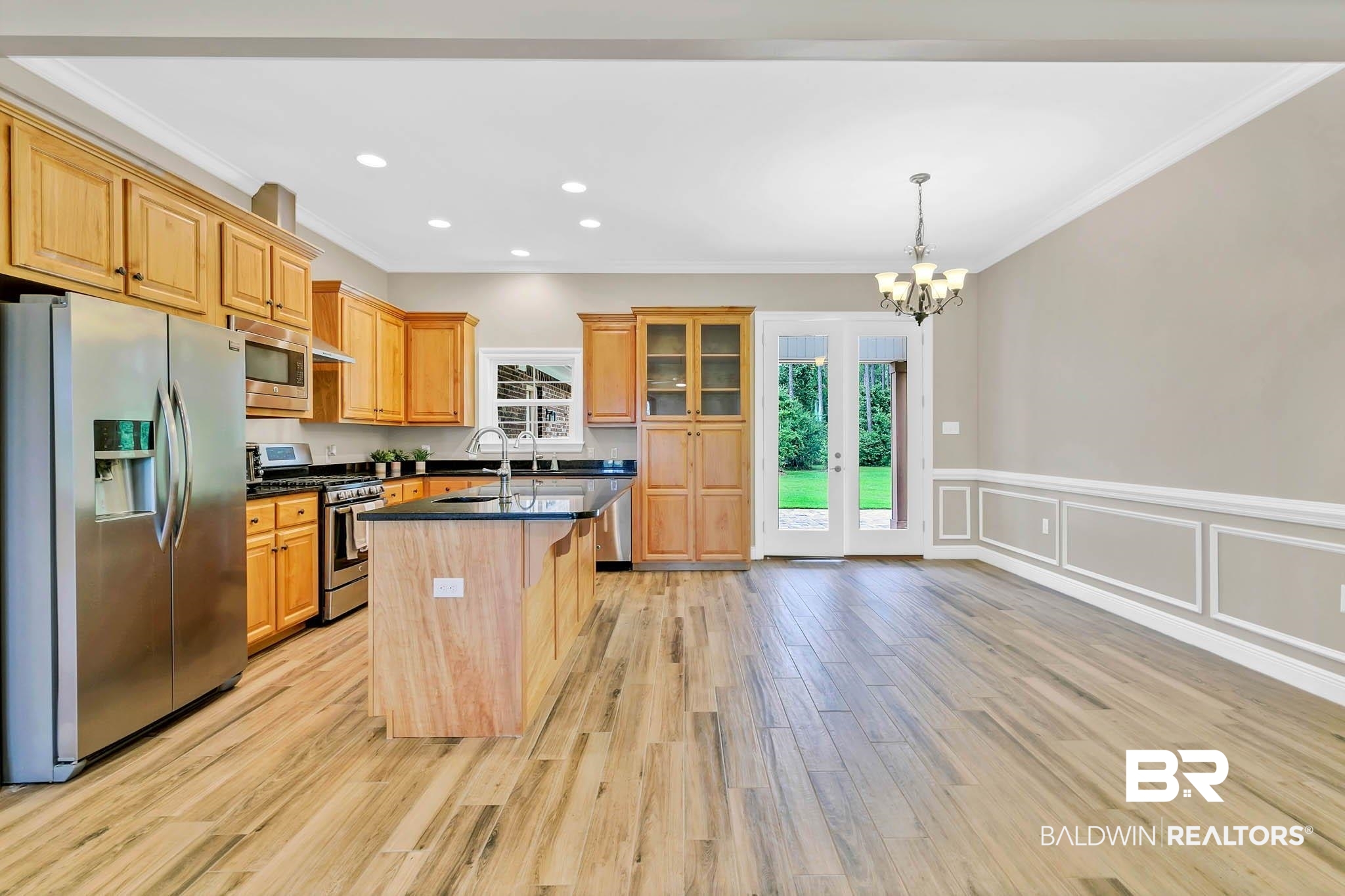 8145 Bay View Drive Foley, AL 36535 - Photo 12 of 81 Kitchen with stainless steel appliances, ornamental molding, a chandelier, dark countertops, and light wood-style floors
