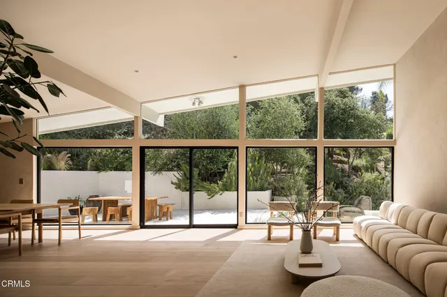 a living room with furniture and a large window with outer view