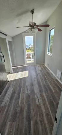 a view of empty room with wooden floor