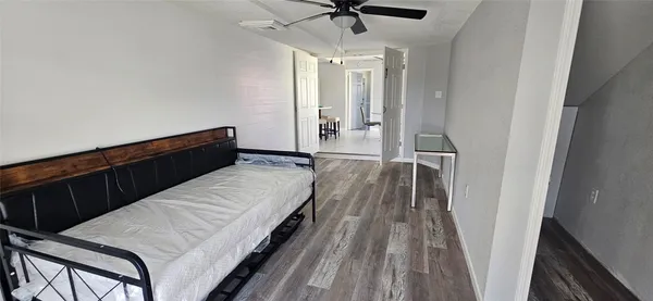 a view of a room with wooden floor and ceiling fan