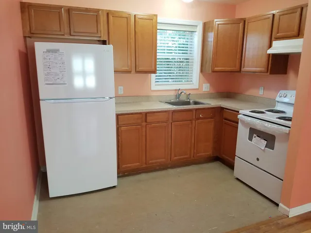 a bathroom with a granite countertop sink and a toilet
