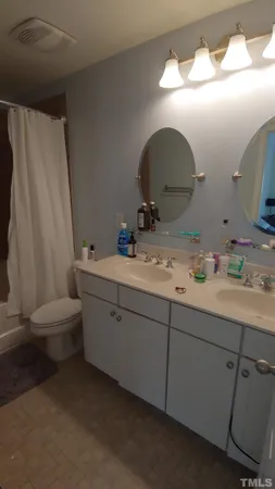a bathroom with a double vanity sink and a mirror