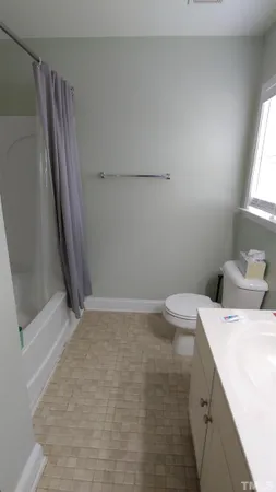 a bathroom with a sink a toilet a window and vanity