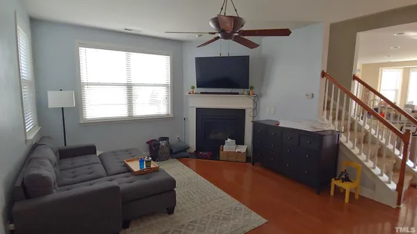 a living room with furniture a flat screen tv and a fireplace