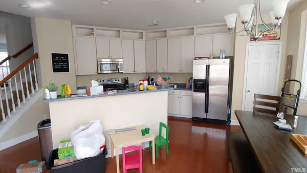a kitchen with stainless steel appliances a refrigerator sink and white cabinets