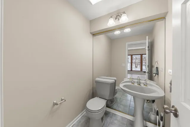 a bathroom with a toilet sink and mirror