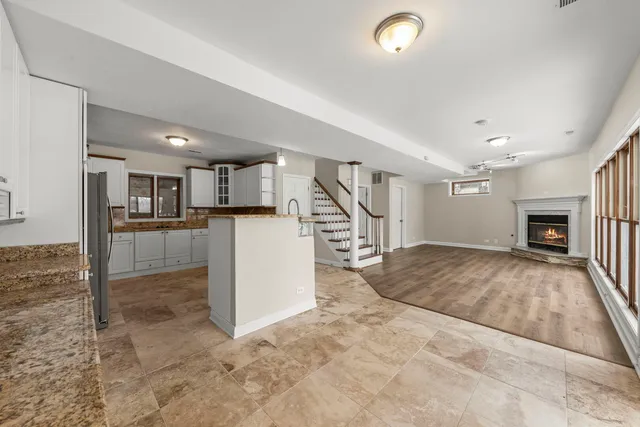 a view of a livingroom with kitchen and fireplace