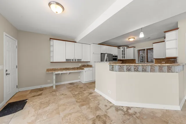 a kitchen with a refrigerator and a stove top oven