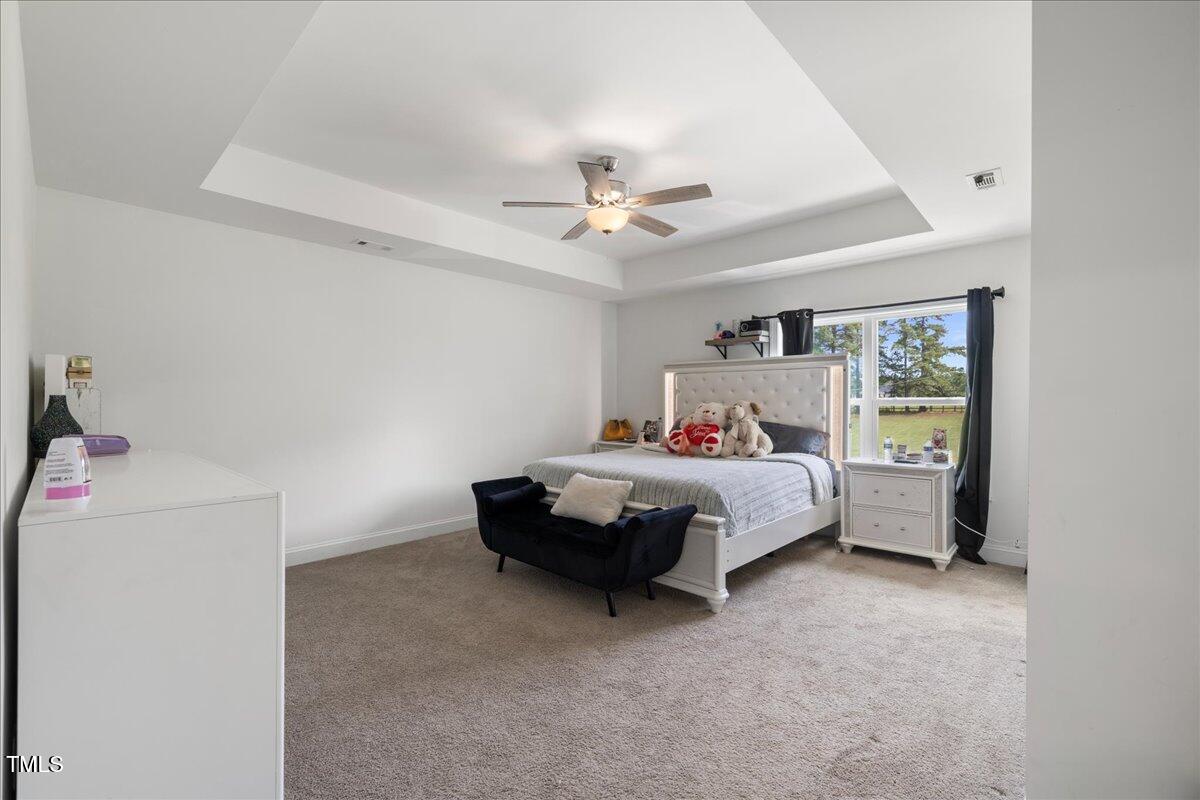 5421 West Old Spring Hope Road Spring Hope, NC 27882 - Photo 15 of 54 a bedroom with a bed and a chandelier