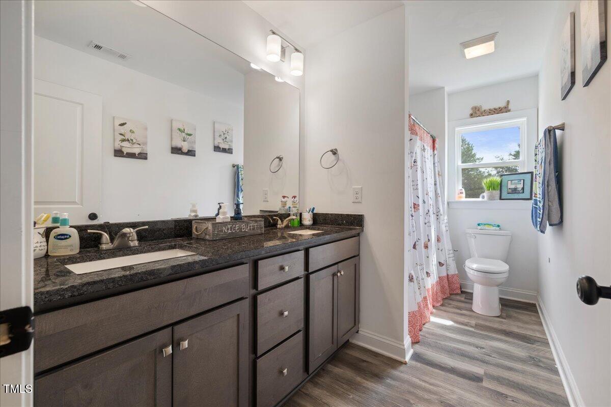 5421 West Old Spring Hope Road Spring Hope, NC 27882 - Photo 24 of 54 a bathroom with a sink double vanity granite toilet and a shower
