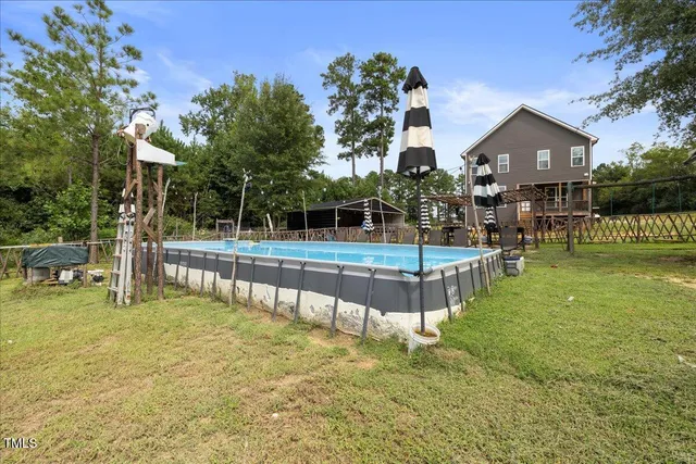 a view of a swimming pool with chairs and fire pit