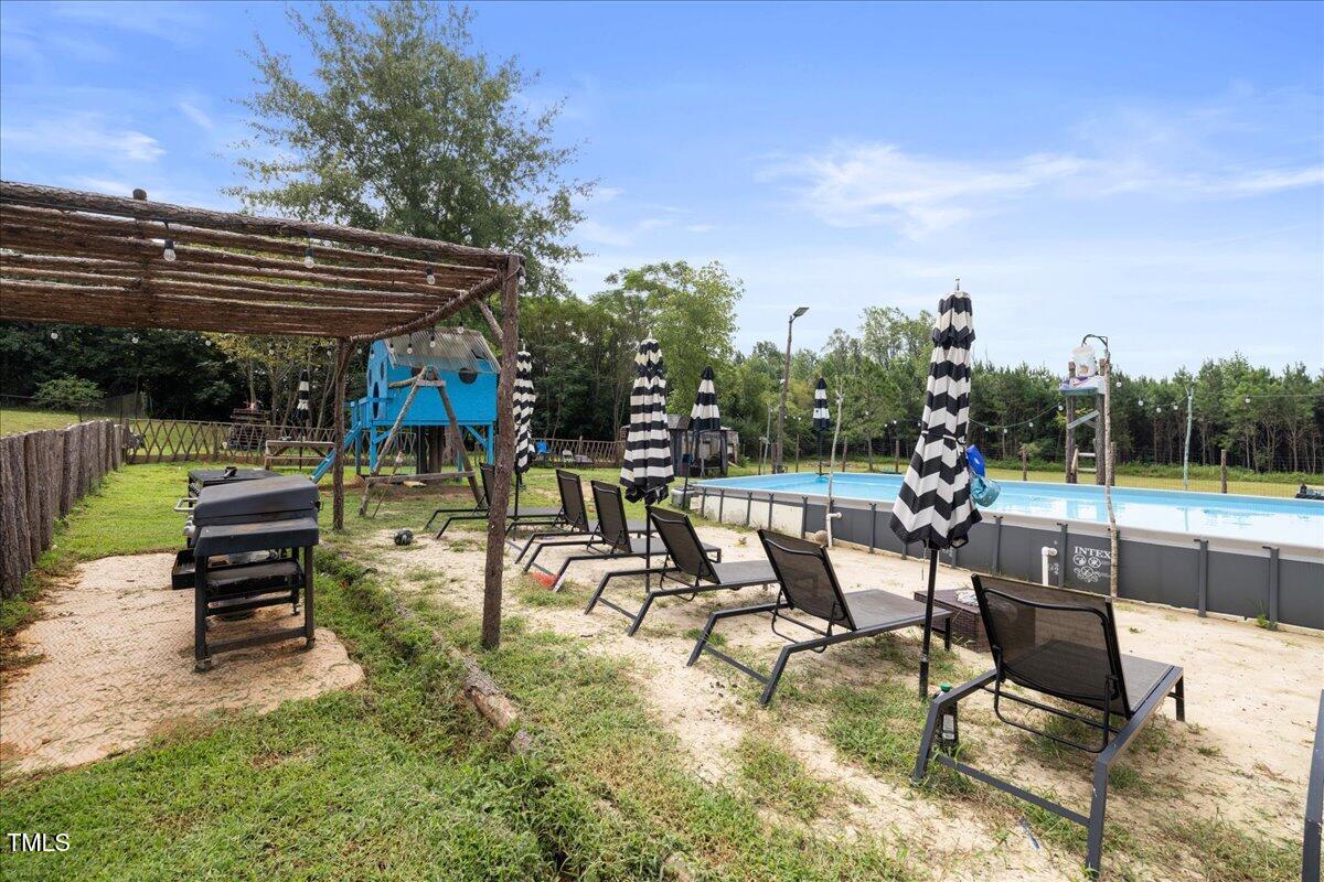 5421 West Old Spring Hope Road Spring Hope, NC 27882 - Photo 39 of 54 a view of a swimming pool with chairs and fire pit