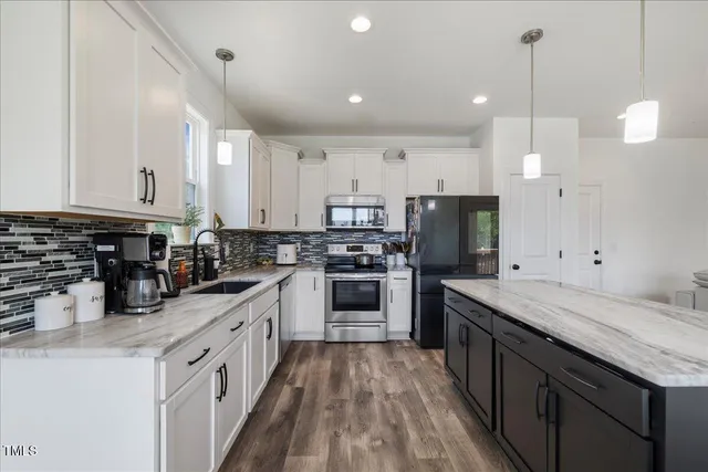 a kitchen with stainless steel appliances granite countertop a sink refrigerator and cabinets