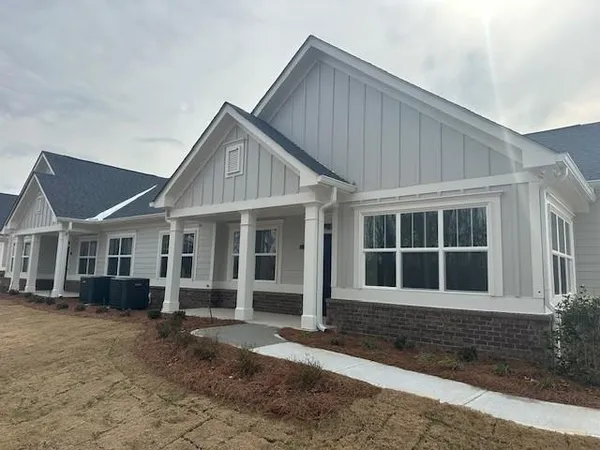 a front view of a house with a yard and seating space