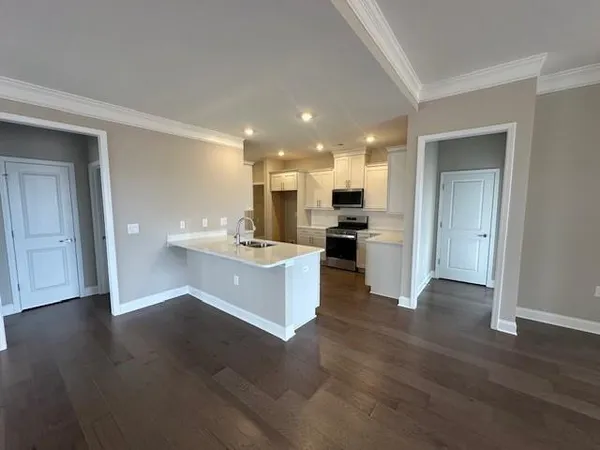a view of kitchen with kitchen island wooden floor center island and stainless steel appliances