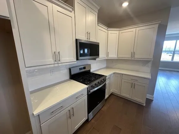 a kitchen with white cabinets and white appliances