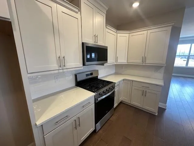 a kitchen with white cabinets and white appliances
