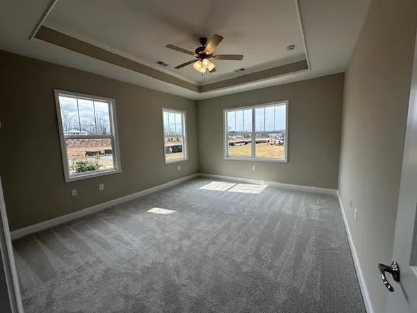 an empty room with windows and ceiling fan