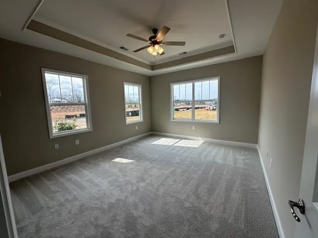 an empty room with windows and ceiling fan