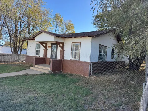 a view of a house with backyard and trees