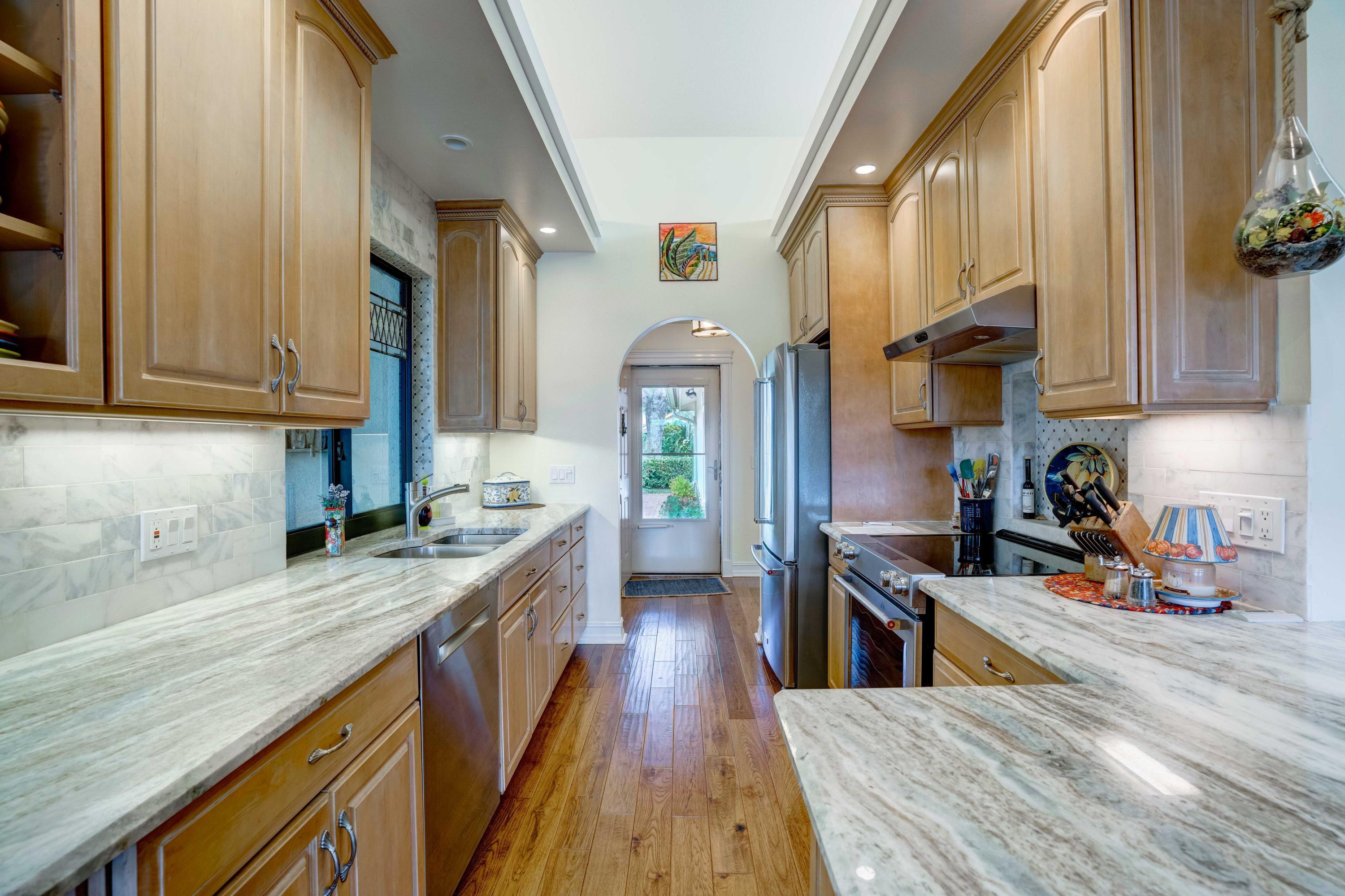 332 River Edge Road Jupiter, FL 33477 - Photo 13 of 103 a kitchen with stainless steel appliances granite countertop a refrigerator a sink dishwasher a stove and white cabinets with wooden floor