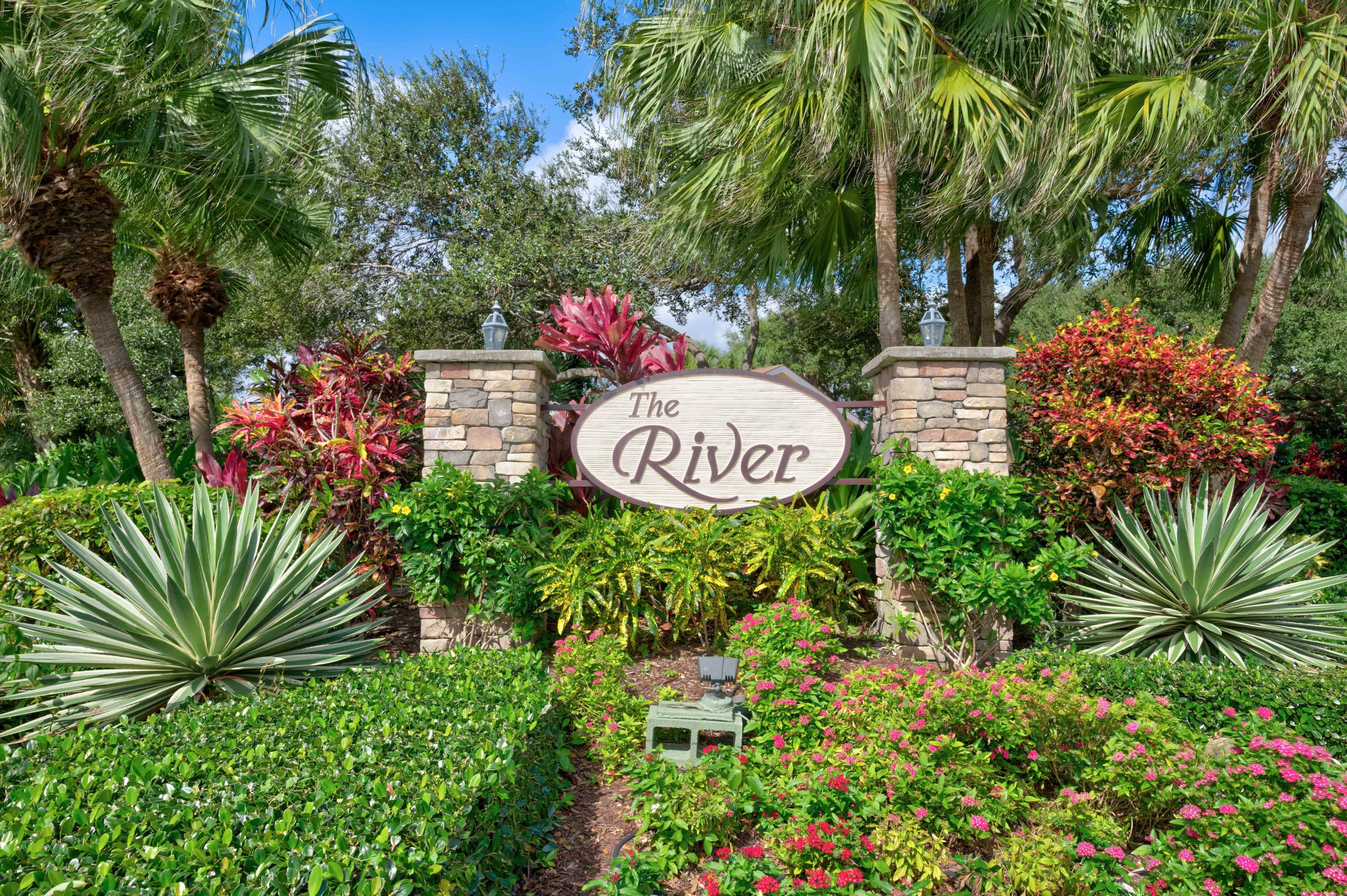 332 River Edge Road Jupiter, FL 33477 - Photo 34 of 103 a view of a sign in a yard with potted plants and large trees