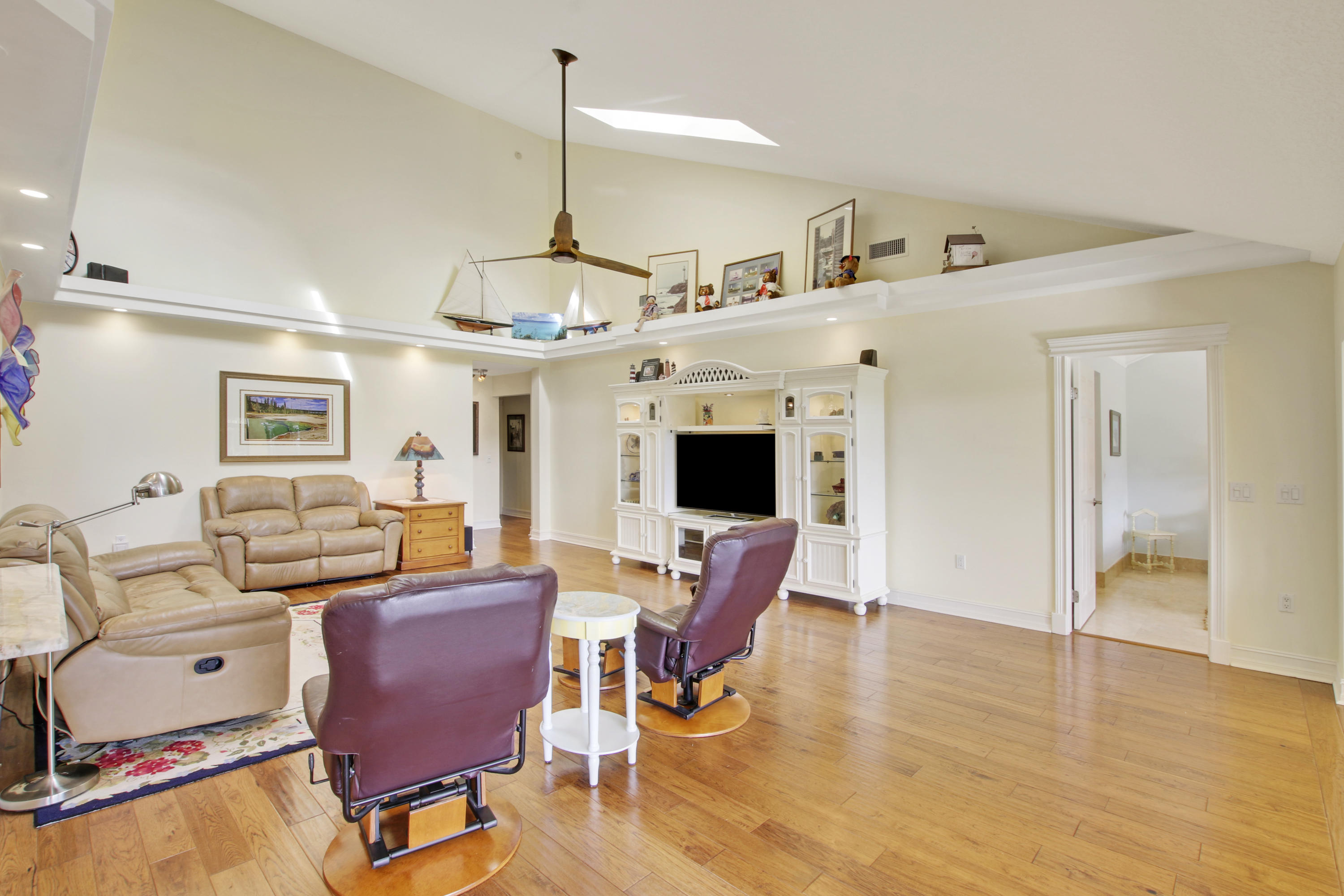 332 River Edge Road Jupiter, FL 33477 - Photo 79 of 103 a view of a livingroom with furniture a flat screen tv and wooden floor