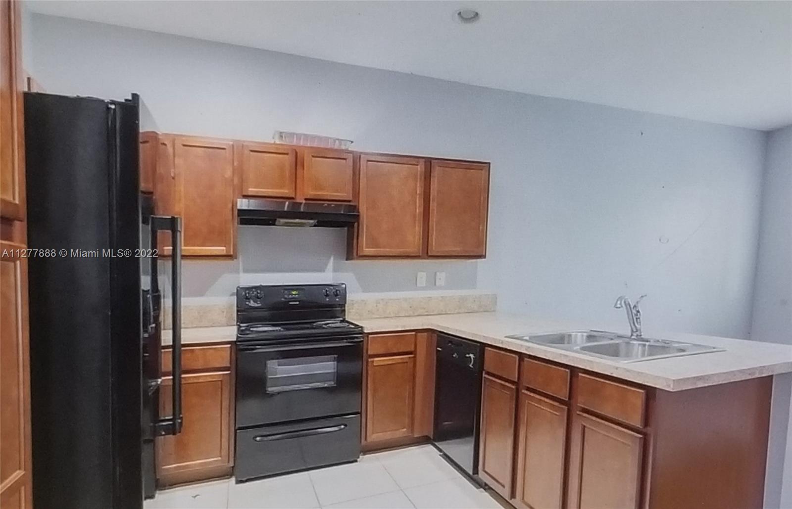 Walden Miami Gardens, FL 33169 - Photo 3 of 7 a kitchen with a refrigerator and a sink