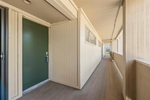 a view of a hallway with wooden floors and stairs