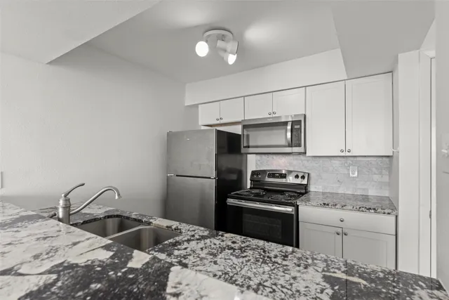 a kitchen with a sink refrigerator and microwave