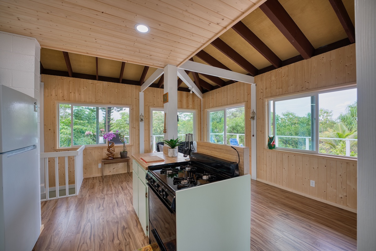 14-3674 Government Beach Road Pahoa, HI 96778 - Photo 7 of 29 a kitchen with stainless steel appliances granite countertop a stove a refrigerator a sink and wooden floors