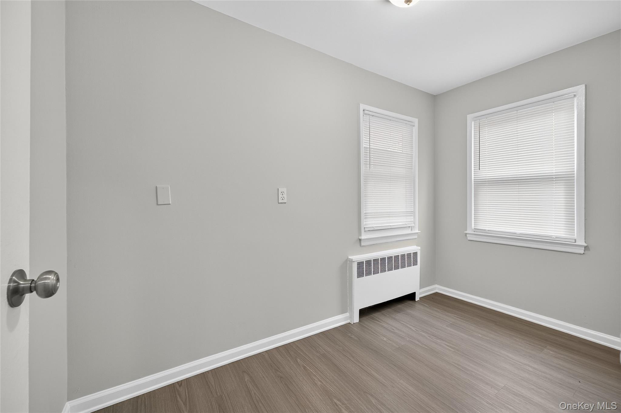 552 Old Country Road Plainview, NY 11803 - Photo 12 of 19 an empty room with wooden floor cabinet and windows