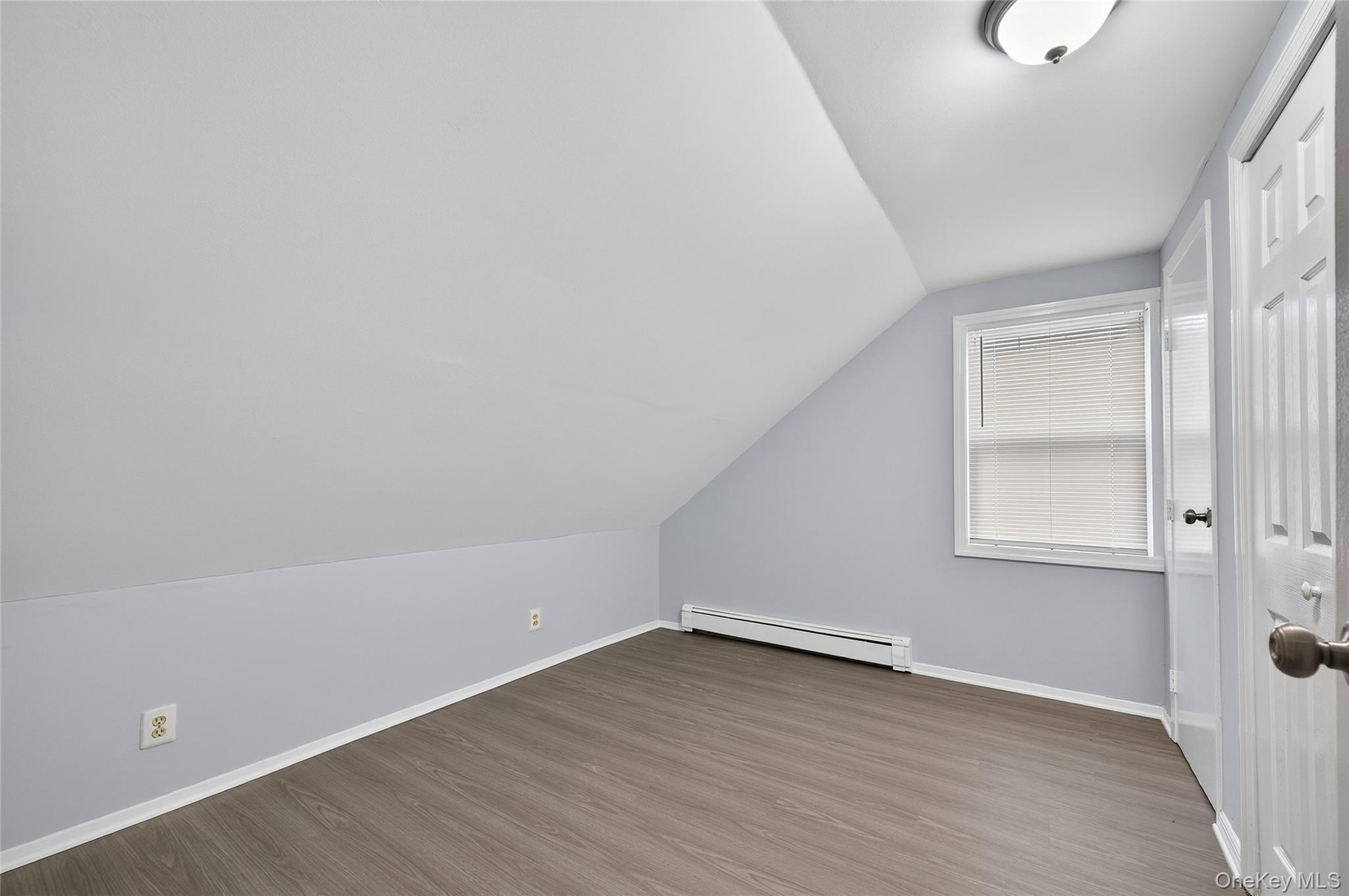 552 Old Country Road Plainview, NY 11803 - Photo 17 of 19 an empty room with wooden floor and windows