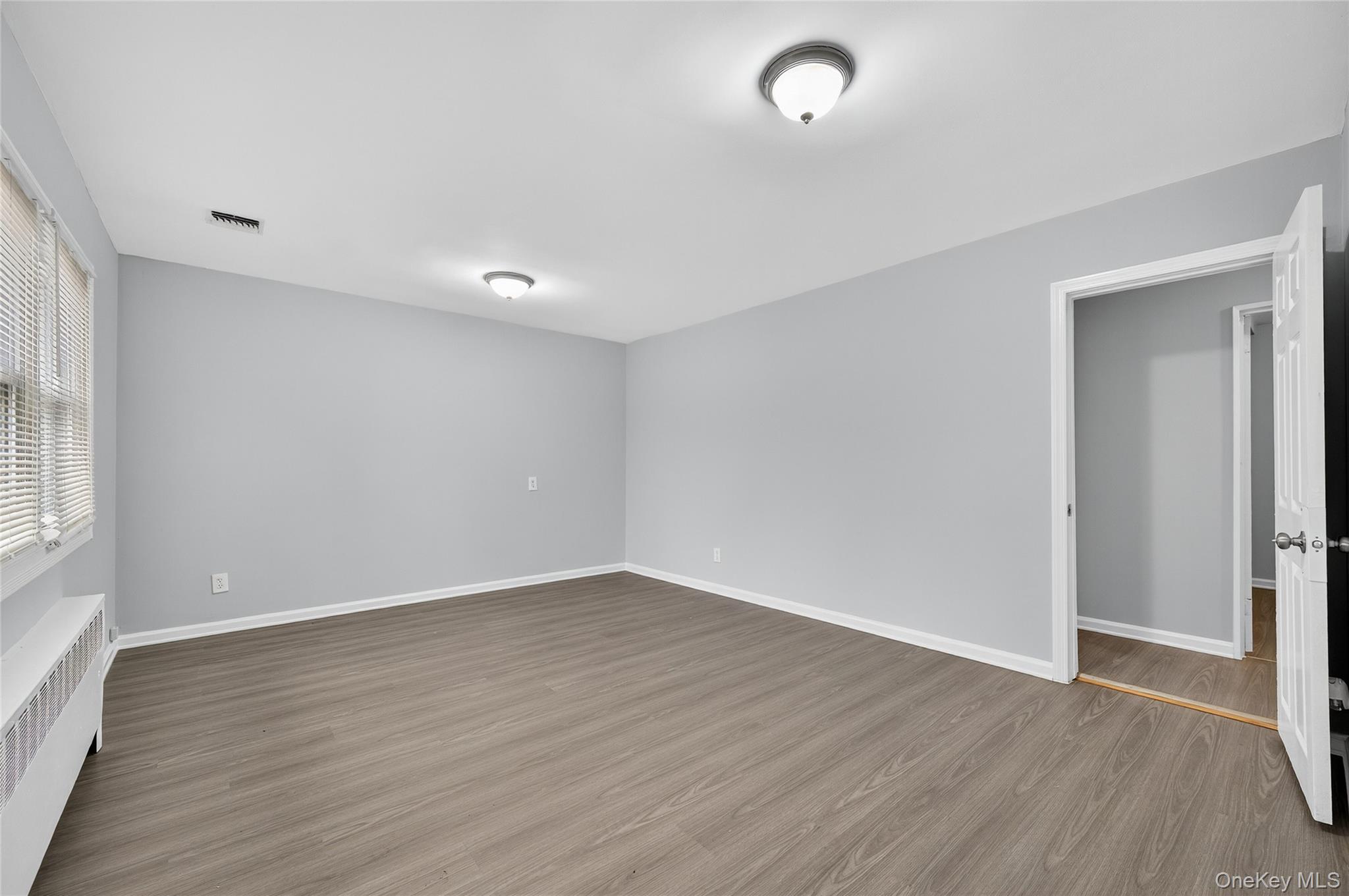 552 Old Country Road Plainview, NY 11803 - Photo 2 of 19 an empty room with wooden floor and windows