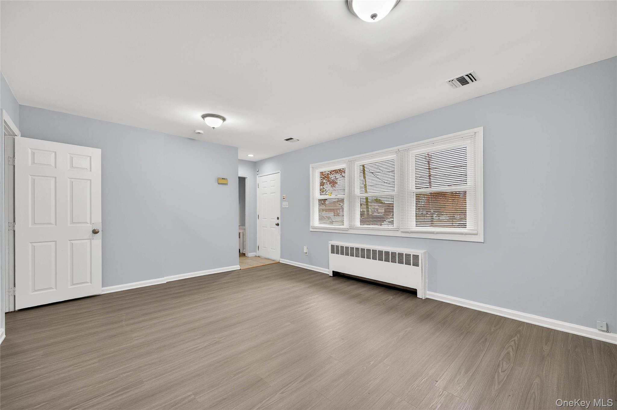 552 Old Country Road Plainview, NY 11803 - Photo 3 of 19 a view of an empty room with wooden floor and a window