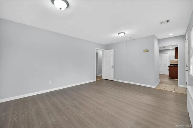 a view of an empty room with wooden floor