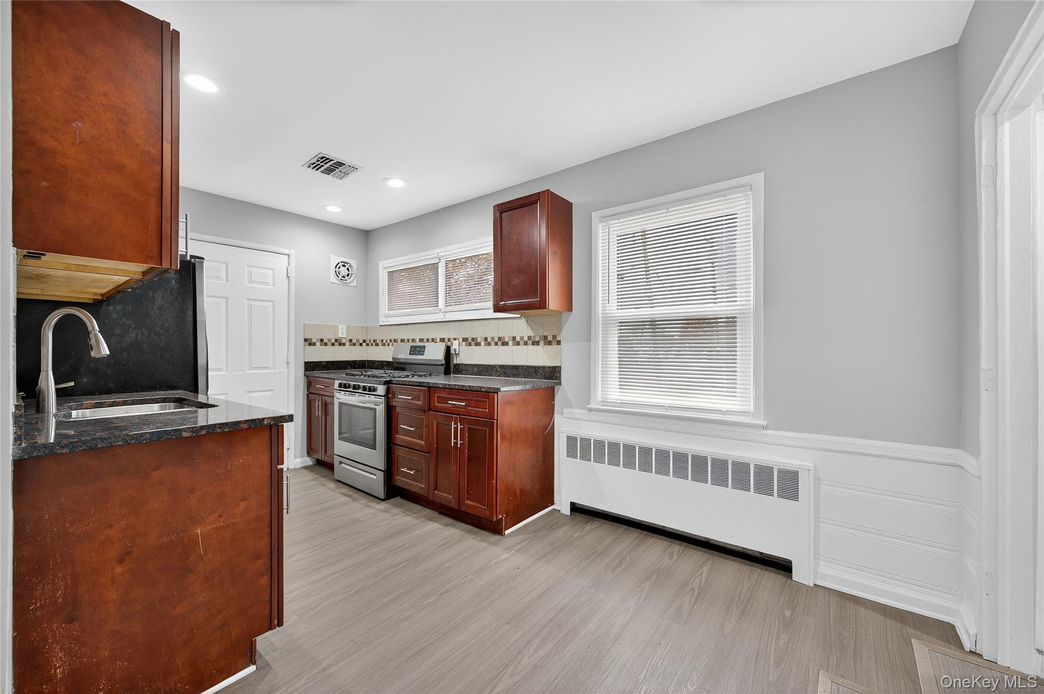 552 Old Country Road Plainview, NY 11803 - Photo 5 of 19 a kitchen with stainless steel appliances granite countertop a stove a sink and a refrigerator