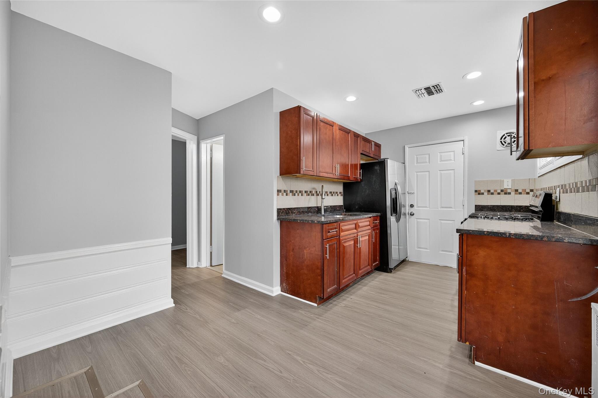 552 Old Country Road Plainview, NY 11803 - Photo 6 of 19 a kitchen with stainless steel appliances granite countertop a stove top oven a sink and a refrigerator