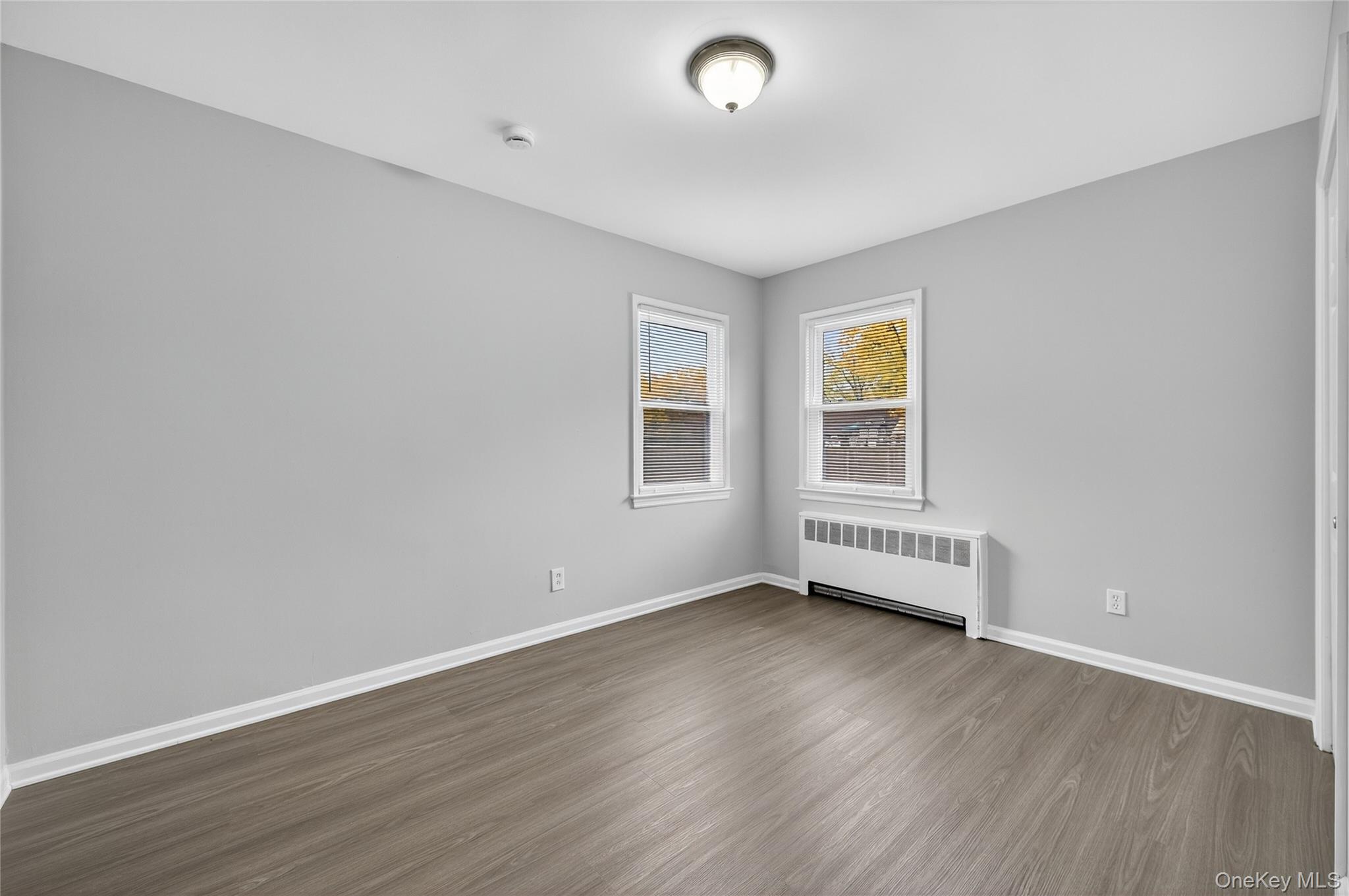 552 Old Country Road Plainview, NY 11803 - Photo 8 of 19 a view of an empty room with wooden floor and a window