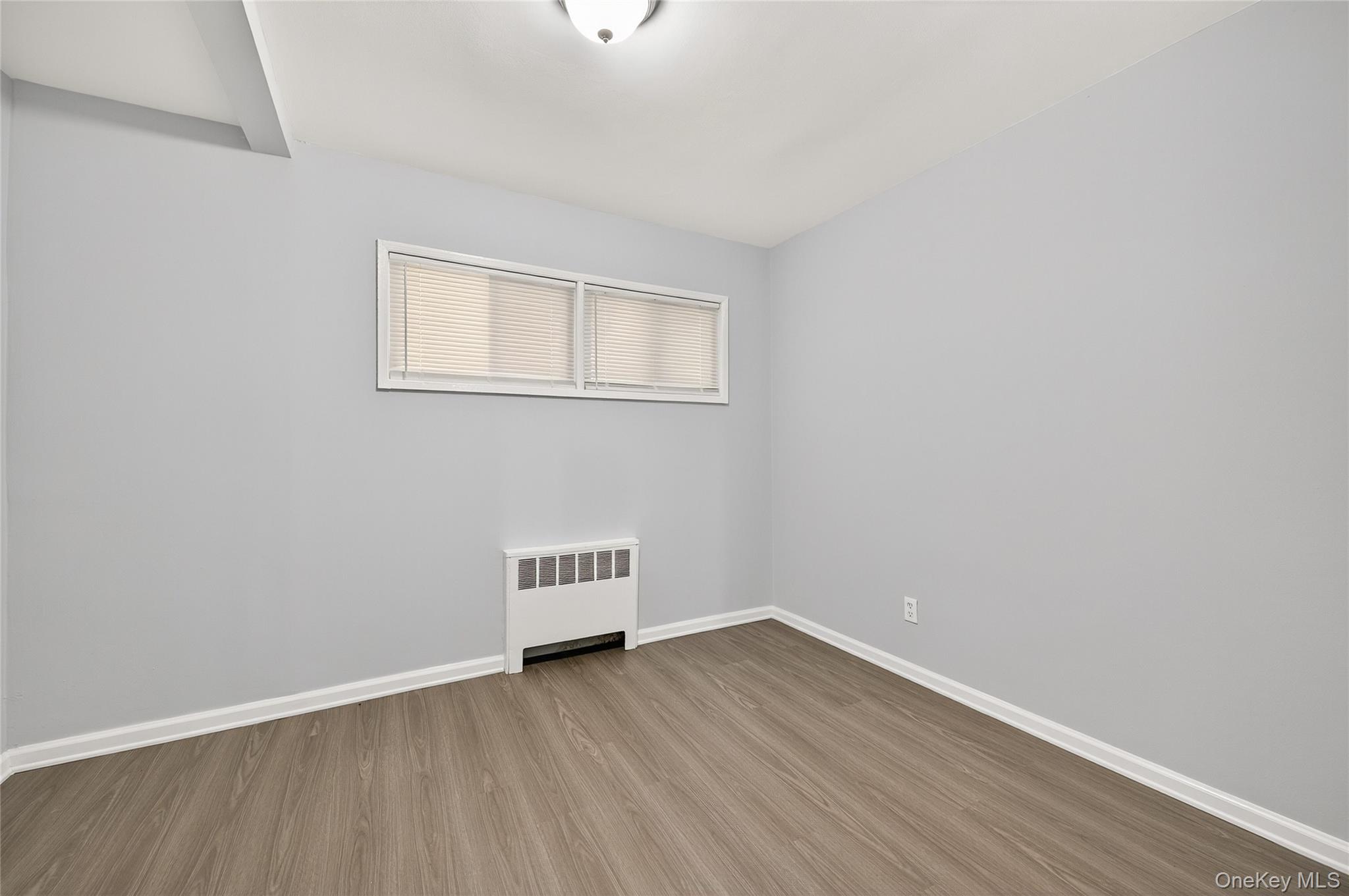 552 Old Country Road Plainview, NY 11803 - Photo 10 of 19 a view of a room with wooden floor and white walls