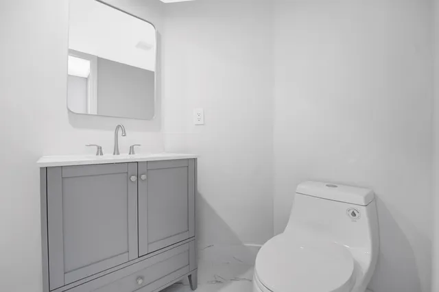 a white toilet sitting next to a bathroom sink