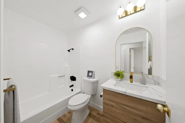 a bathroom with a granite countertop toilet a sink and a bathtub