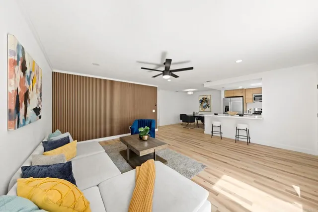 a living room with stainless steel appliances furniture a rug and a window