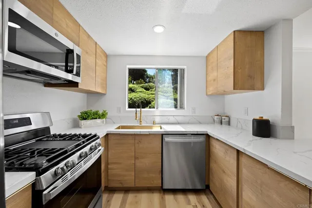 a kitchen with stainless steel appliances a sink stove and microwave